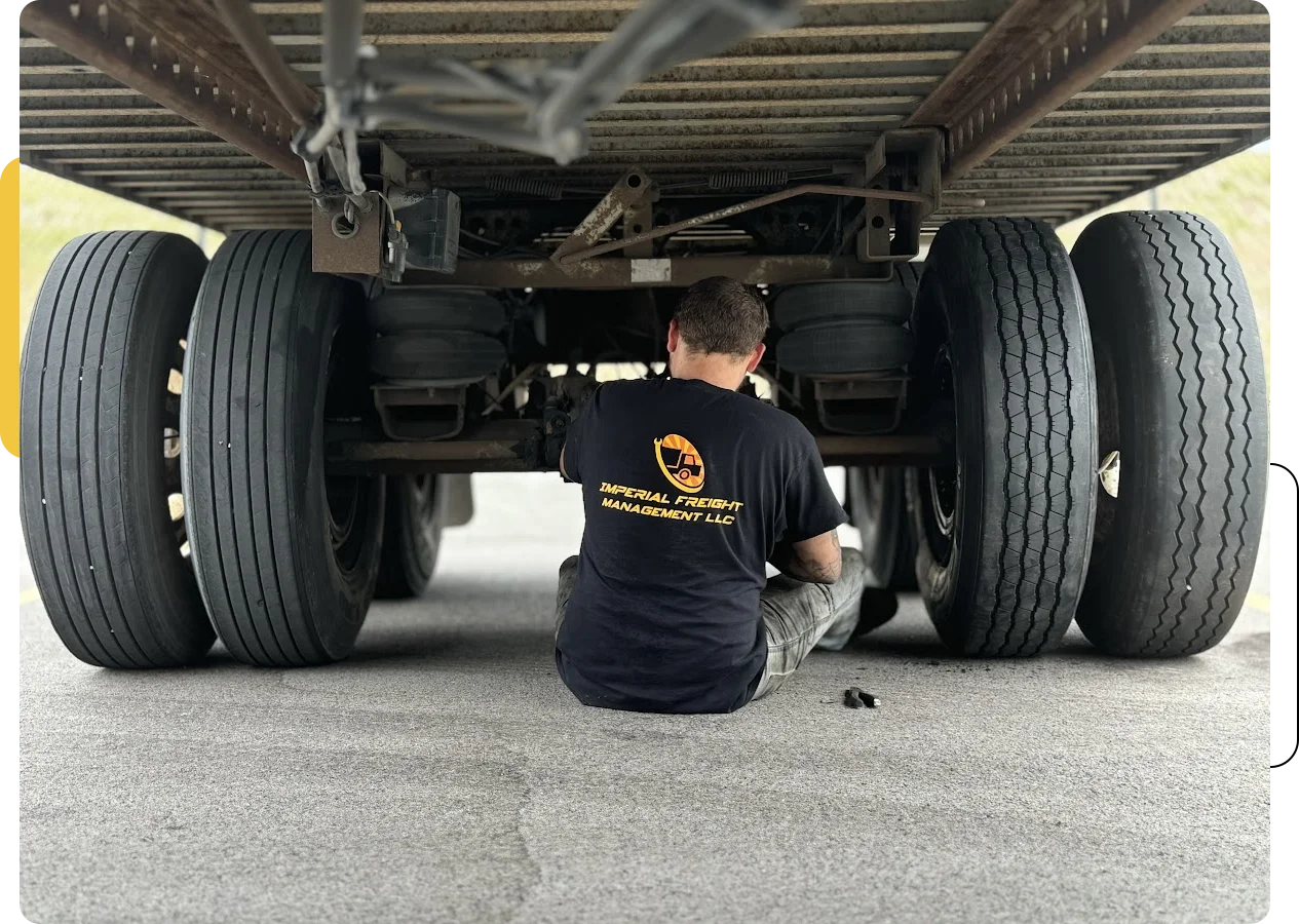 A man working underneath an unbalanced truck.