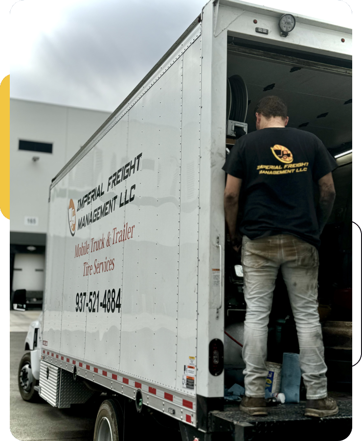 A man standing in the back of a moving truck.